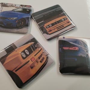 Può includere: Quattro sottobicchieri quadrati con immagini di auto. Uno mostra un'auto blu, un altro un'auto gialla, e gli altri mostrano diverse angolazioni di auto. I sottobicchieri hanno una finitura lucida.