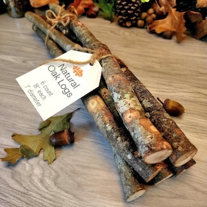 May include: A bundle of six natural oak logs, each 18 inches long and 1 inch in diameter, tied together with twine. A white paper tag is attached to the bundle with the text Natural Oak Logs, 6 count, 18 inch each, 1 inch diameter.