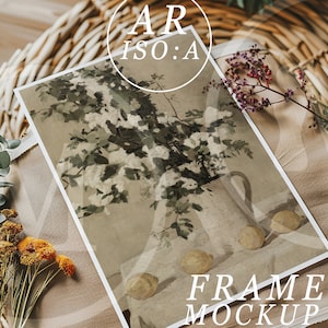 Op de afbeelding: Een ingelijste kunstdruk met een stilleven met een witte kan vol bloemen en citroenen. De print wordt gepresenteerd op een beige stof met gedroogde bloemen en de tekst "FRAME MOCKUP". De afbeelding heeft een vintage esthetiek.