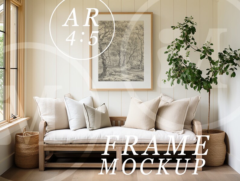 May include: A framed black and white print of a forest scene hangs above a white cushioned bench with beige pillows. A potted green plant stands to the right of the bench. The bench is made of wood and has a woven basket on each end.