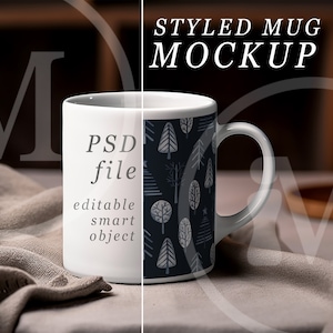 May include: White ceramic mug with a handle, featuring a dark blue pattern of stylized trees and the text "STYLED MUG MOCKUP". The mug is set on a neutral-colored cloth, with a blurred background including a lit candle.