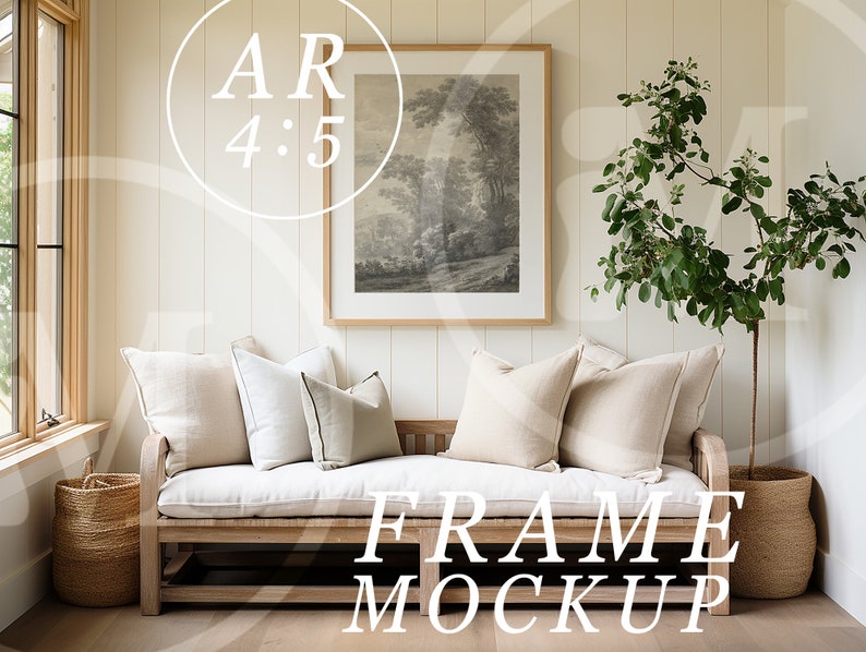 May include: A white framed picture with a black and white landscape print hangs on a light beige wall above a wooden bench with white cushions. A potted plant with green leaves stands to the right of the bench. The text "FRAME MOCKUP" is printed in white on the floor in front of the bench.