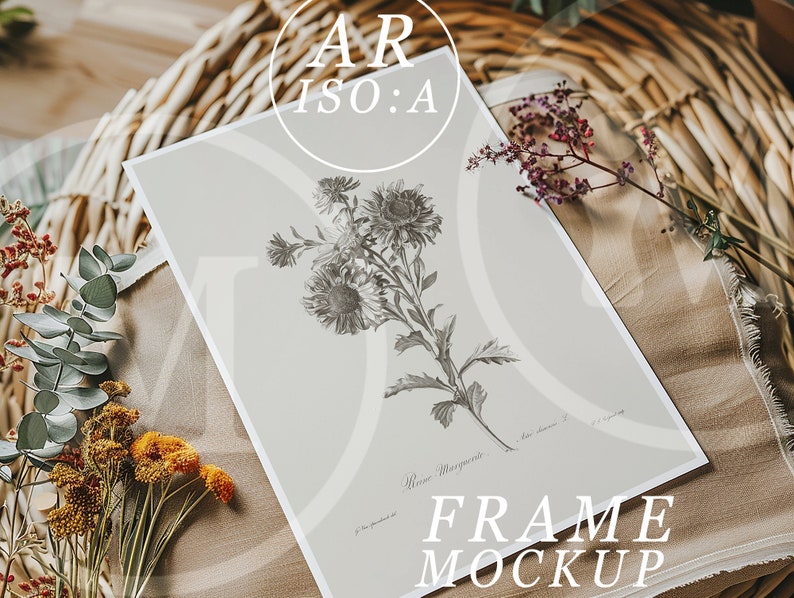 Op de afbeelding: Een ingelijste botanische print met een gedetailleerde grijswaarden illustratie van bloemen, met de tekst "Reine Marguerite" en "FRAME MOCKUP". De print wordt gepresenteerd op een neutrale ondergrond, omringd door gedroogde bloemen en groen.