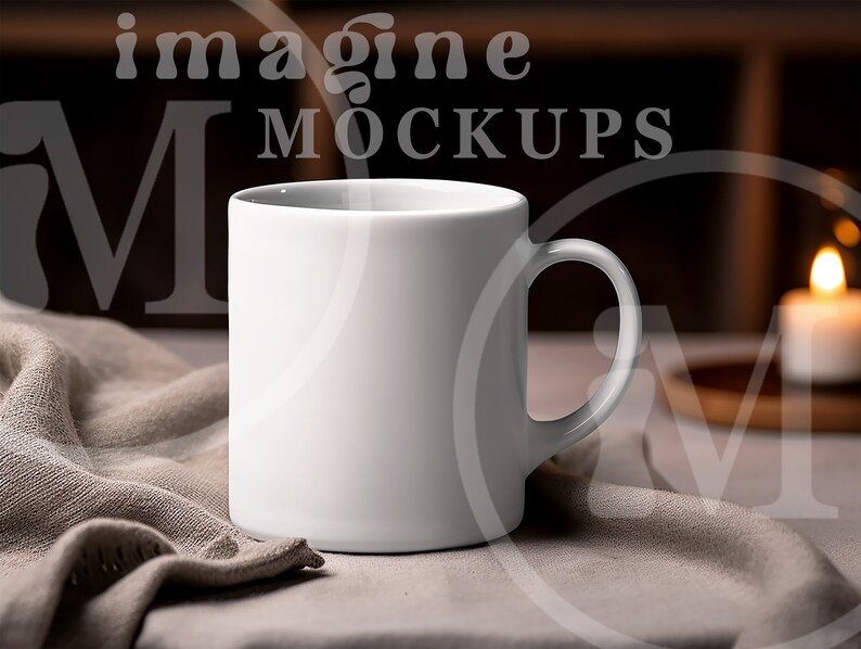 May include: A white ceramic mug with a curved handle sits on a neutral-colored cloth. The mug is the focal point, with the words "imagine MOCKUPS" subtly visible in the background. A lit candle adds warmth to the scene.