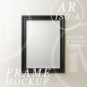 May include: A black picture frame mockup on a white wall. The frame is empty and has a simple design. The text "FRAME MOCKUP" is below the frame.