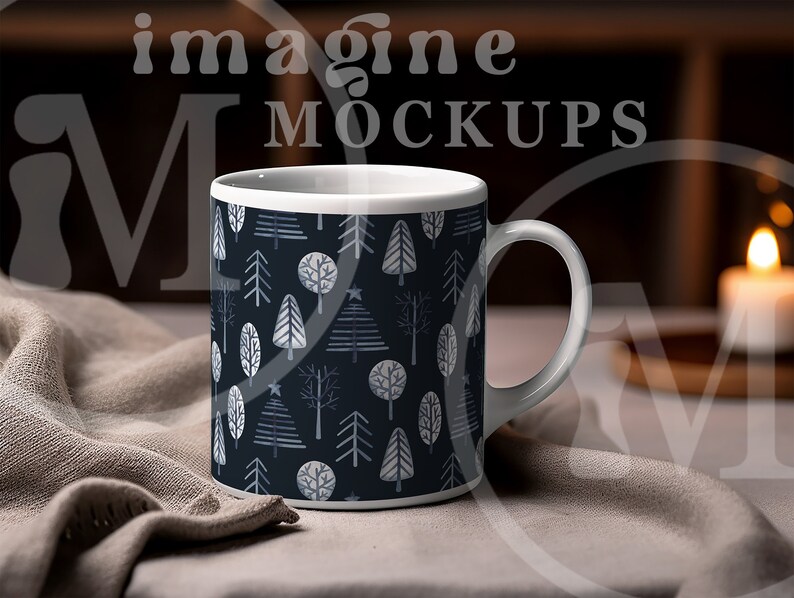 May include: White ceramic mug featuring a dark blue pattern of stylized trees in shades of gray and white. The mug has a white handle and rim. The words "imagine MOCKUPS" are visible in the background.