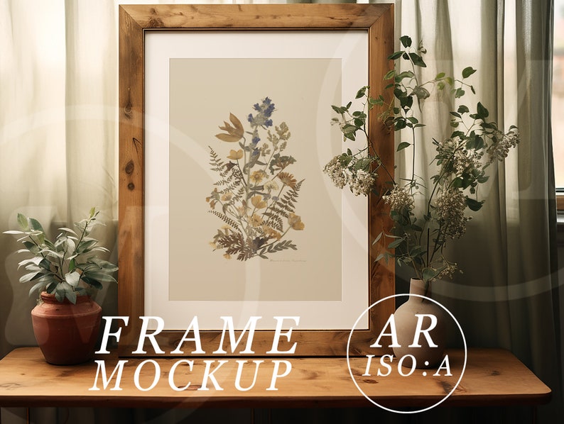May include: A framed botanical print featuring a collection of dried flowers in shades of yellow, blue, and brown. The artwork is displayed in a rustic, light brown wooden frame. The words "FRAME MOCKUP" are at the bottom of the frame.