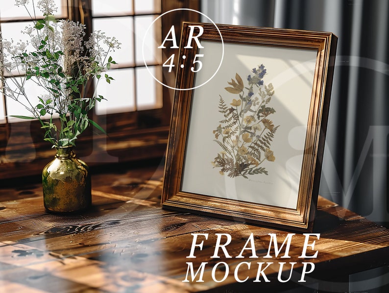 K&ouml;nnte beinhalten: Ein Holzbildrahmen mit goldener Oberfl&auml;che steht auf einem Holztisch. Der Rahmen enth&auml;lt einen Druck von gepressten Blumen und Farnen. Der Text "FRAME MOCKUP" ist unter dem Rahmen gedruckt.