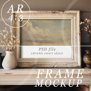 May include: White wooden frame mockup with a painting of a cloudy sky. The frame is sitting on a white mantel with two vases and dried flowers. The text "FRAME MOCKUP" is written below the frame.
