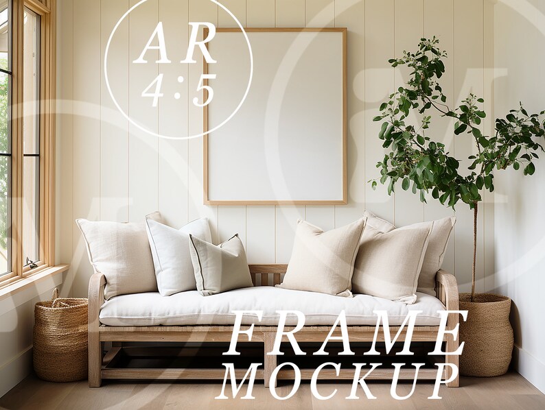 May include: A white couch with beige pillows sits in front of a large, empty picture frame with a wooden frame. A potted plant with green leaves stands to the right of the couch. The text "FRAME MOCKUP" is printed in white on the floor in front of the couch.
