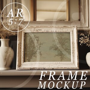 May include: White distressed wood picture frame with a light green and brown image inside. The frame is sitting on a brown shelf with two white vases and dried flowers on either side. The text "FRAME MOCKUP" is below the frame.