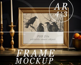 May include: A gold picture frame mockup with a black and white illustration of three crows on a branch. The frame is sitting on a dark wood surface with two gold candle holders and a bowl of oranges.