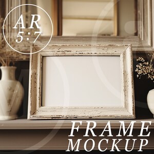 May include: A white picture frame with a distressed finish sits on a brown mantel. The frame is empty and ready for a photo or artwork. The mantel is decorated with dried flowers in white vases.