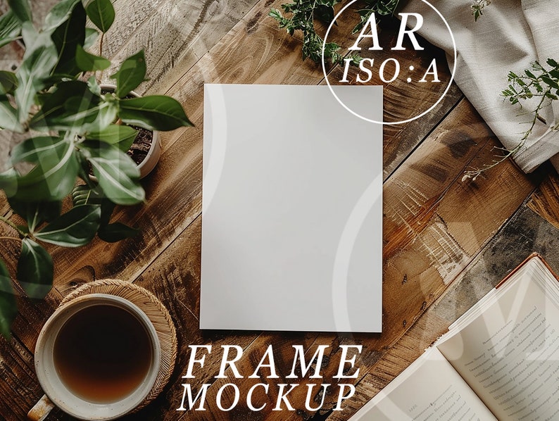 May include: A white frame mockup on a wooden surface with a cup of coffee, a book, and greenery. The text "FRAME MOCKUP" is written below the frame.