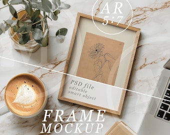 May include: A wooden frame mockup with a drawing of a sunflower inside. The frame is on a white marble surface with a cup of coffee, a potted plant, and a laptop computer. The text "PSD file editable smart object" and "FRAME MOCKUP" are visible in the image.