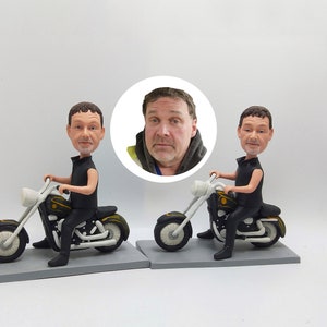Könnte beinhalten: Zwei maßgefertigte Figuren, die eine Person auf einem schwarzen Motorrad zeigen. Die Figuren tragen schwarze Kleidung und haben realistische Gesichtszüge. Die Motorräder haben weiße Räder und gelbe Akzente.