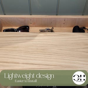 Peut inclure: Une &eacute;tag&egrave;re flottante en bois clair avec un motif de grain visible. L'&eacute;tag&egrave;re est fix&eacute;e au mur et contient des lunettes de soleil noires, un trousseau de cl&eacute;s en m&eacute;tal et un petit objet noir. Le texte "Lightweight design Easier to install" est visible.