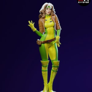 Puede incluir: Figura detallada de Rogue de X-Men, en una pose dinámica. La figura lleva un body verde y amarillo, una chaqueta marrón y botas amarillas. El personaje tiene el pelo blanco y una diadema verde. La base es de piedra clara.