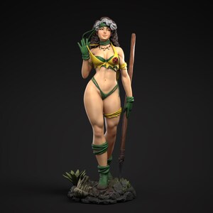 Könnte beinhalten: Eine grün-gelbe Actionfigur einer weiblichen Figur mit einem Stab. Sie trägt einen grün-gelben Bikini und hat langes braunes Haar mit einem weißen Streifen. Sie steht auf einem felsigen Sockel mit grünen Pflanzen.