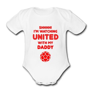 May include: White baby grow with red text that reads "Shhhh! I'm watching United with my Daddy" and a red football graphic.