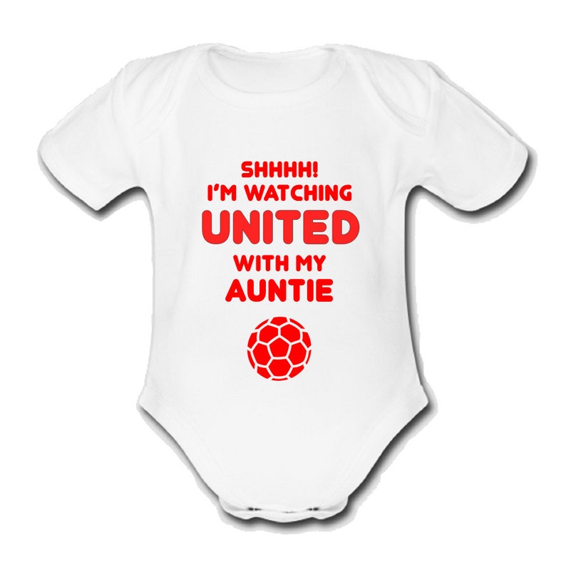 May include: White baby grow with red text that reads "Shhhh! I'm watching United with my Auntie" and a red football graphic.