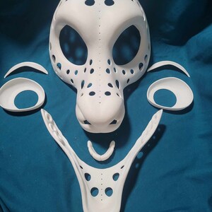 May include: White unfinished mask with multiple holes and a separate nose piece. The mask is made of a smooth, hard material and is ready to be painted.
