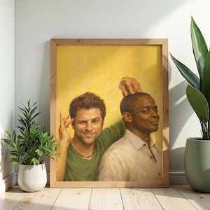 May include: A framed print featuring two men in a portrait style. One man is wearing a green shirt and the other is wearing a white shirt. The background is yellow. The frame is made of wood.