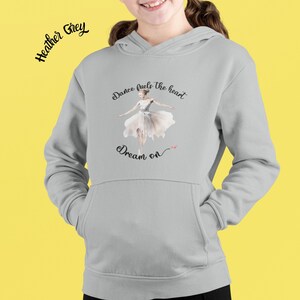 Könnte beinhalten: Grauer Kapuzenpullover mit einem Ballerina-Motiv und dem Text "Dance fuels the heart. Dream on."