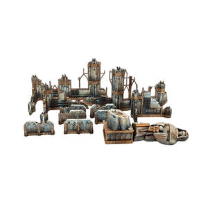 Può includere: Una collezione di rovine di edifici in miniatura, grigie e marroni, usurate. Il set include vari elementi architettonici come muri, torri e detriti, progettati per giochi da tavolo o modellismo. I pezzi sono disposti su sfondo bianco.