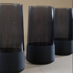 May include: Three dark gray glass tumblers with a black painted bottom.