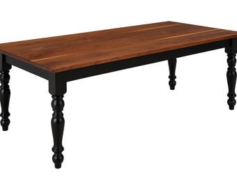 May include: A rectangular wooden dining table with a dark brown tabletop and a black frame. The table has four black, turned legs. The tabletop is approximately 72 inches long and 36 inches wide.