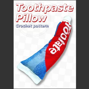 May include: A crochet pattern for a toothpaste pillow featuring a red, white, and blue tube design. The text Toothpaste Pillow Crochet pattern is displayed in white and red lettering against a white background with a subtle checkered pattern.