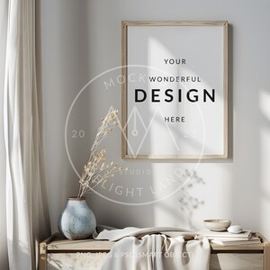 May include: A wooden frame with a white mat and a white background. The text "YOUR WONDERFUL DESIGN HERE" is printed in black on the white background. The frame is hanging on a white wall with a vase of dried flowers and a wooden table in the foreground.