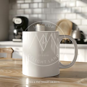 Pode incluir: Caneca de cerâmica branca com alça, sentada em uma mesa de madeira. A caneca tem o texto "MOCKUP STUDIO DELIGHT LAND" impresso nela.