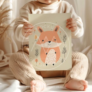 May include: A child holds a printable art print featuring a cute cartoon fox in a forest setting. The print has a light green background with brown trees and orange leaves.