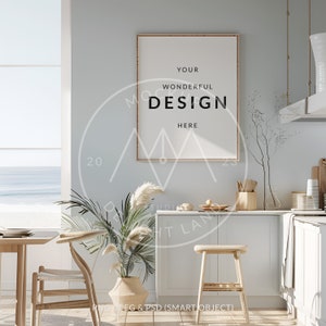 May include: A framed poster with the text "YOUR WONDERFUL DESIGN HERE" hanging on a light blue wall in a kitchen with a wooden countertop, a white cabinet, and a window with a view of the ocean.