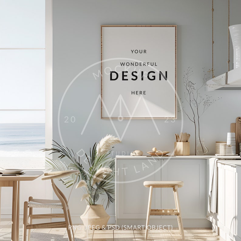 May include: A framed poster with the text "YOUR WONDERFUL DESIGN HERE" hanging on a light blue wall in a kitchen with a wooden countertop, a white cabinet, and a window with a view of the ocean.