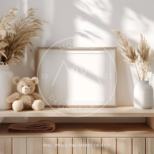 May include: A wooden shelf with a brown teddy bear, a vase with dried pampas grass, and a framed picture. The shelf is part of a wooden cabinet with a brown blanket on the top shelf.