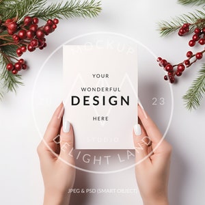 May include: A white card mockup with the text "YOUR WONDERFUL DESIGN HERE STUDIO DELIGHT LAND" and the number "23" on a white background with green pine branches and red berries.