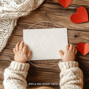 Mão de bebê segurando maquete de cartão, proporção 7:5, maquete de convite de amor, cartão de dia dos namorados, objeto inteligente PSD, download instantâneo
