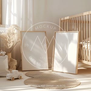 Può includere: Due cornici per foto in legno vuote con una finitura in legno naturale, in piedi su un tappeto intrecciato marrone chiaro in un ambiente da nursery. Le cornici sono posizionate davanti a una culla bianca con una coperta bianca e beige.