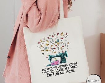 May include: A white tote bag with a colorful illustration of a sewing machine and sewing supplies. The text on the bag reads "And into the sewing room I go to lose my mind and find my soul."