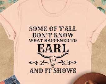 May include: A pink t-shirt with the text "Some of y'all don't know what happened to Earl and it shows". The text is in black and there is a black skull and horns graphic below the text.