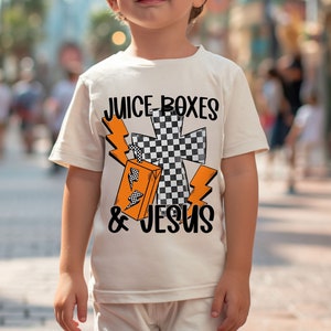a young boy standing on a sidewalk wearing a t - shirt that says juice boxes
