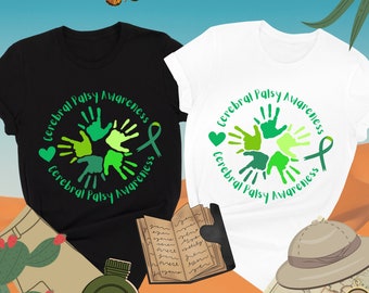 May include: Two t-shirts, one black and one white, with a green handprint design and the text "Cerebral Palsy Awareness".