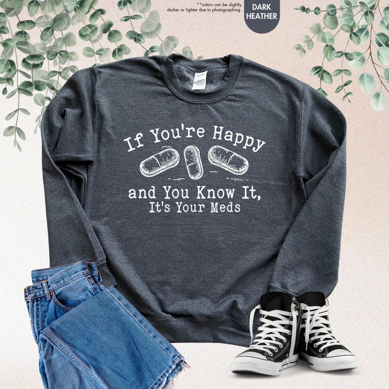 May include: Dark heather grey sweatshirt with a white graphic print that says "If You're Happy and You Know It, It's Your Meds" with three pill illustrations.