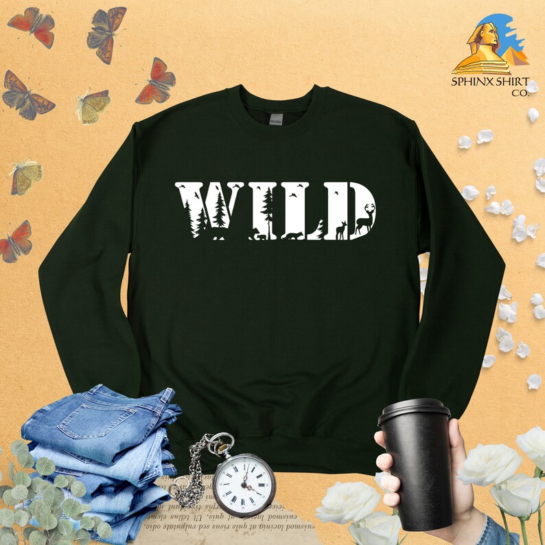 May include: A dark green sweatshirt with the word "WILD" printed in white. The letters are filled with images of trees, animals, and other nature-themed elements.