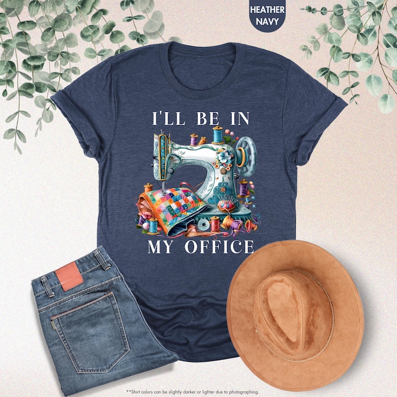 K&ouml;nnte beinhalten: Ein heidefarbenes marineblaues T-Shirt mit einer wei&szlig;en Grafik einer Vintage-N&auml;hmaschine und dem Text "I'll be in my office".