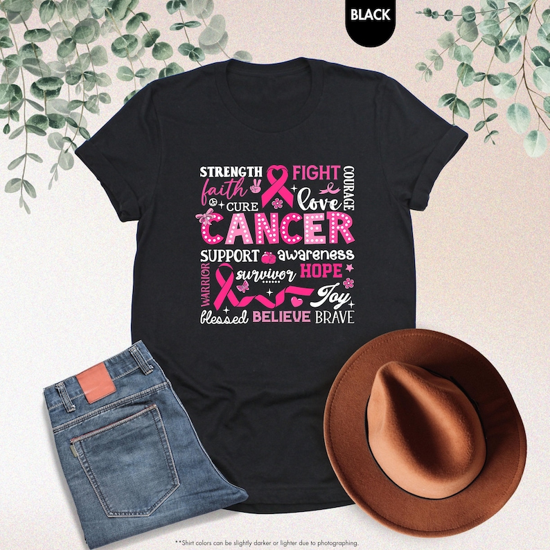 a t - shirt with a pink ribbon and a hat next to it