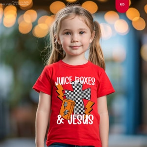 a little girl wearing a red shirt with a checkered cross on it